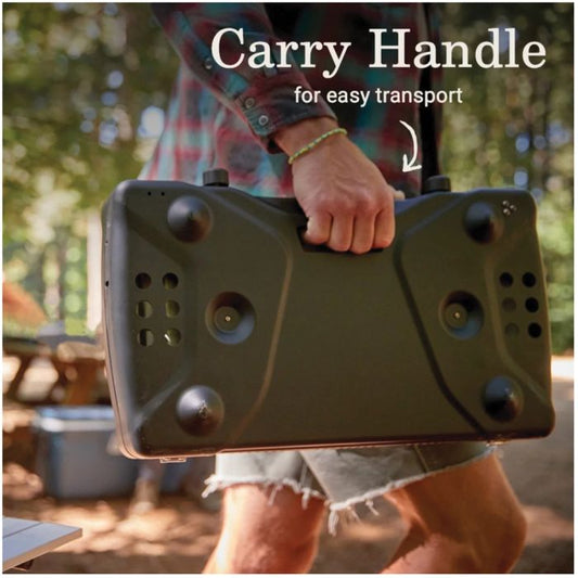 Person holding a portable device with a carry handle outdoors