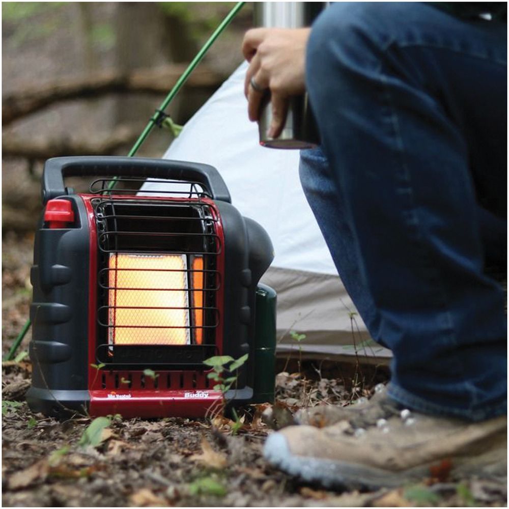 Person using a portable propane heater outdoors