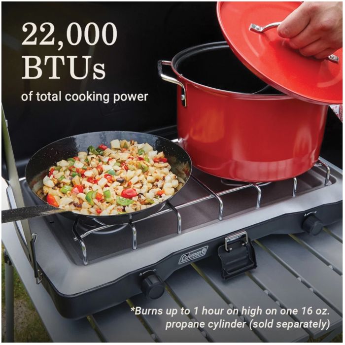Camp stove with pots and pans on a black background, highlighting cooking power.