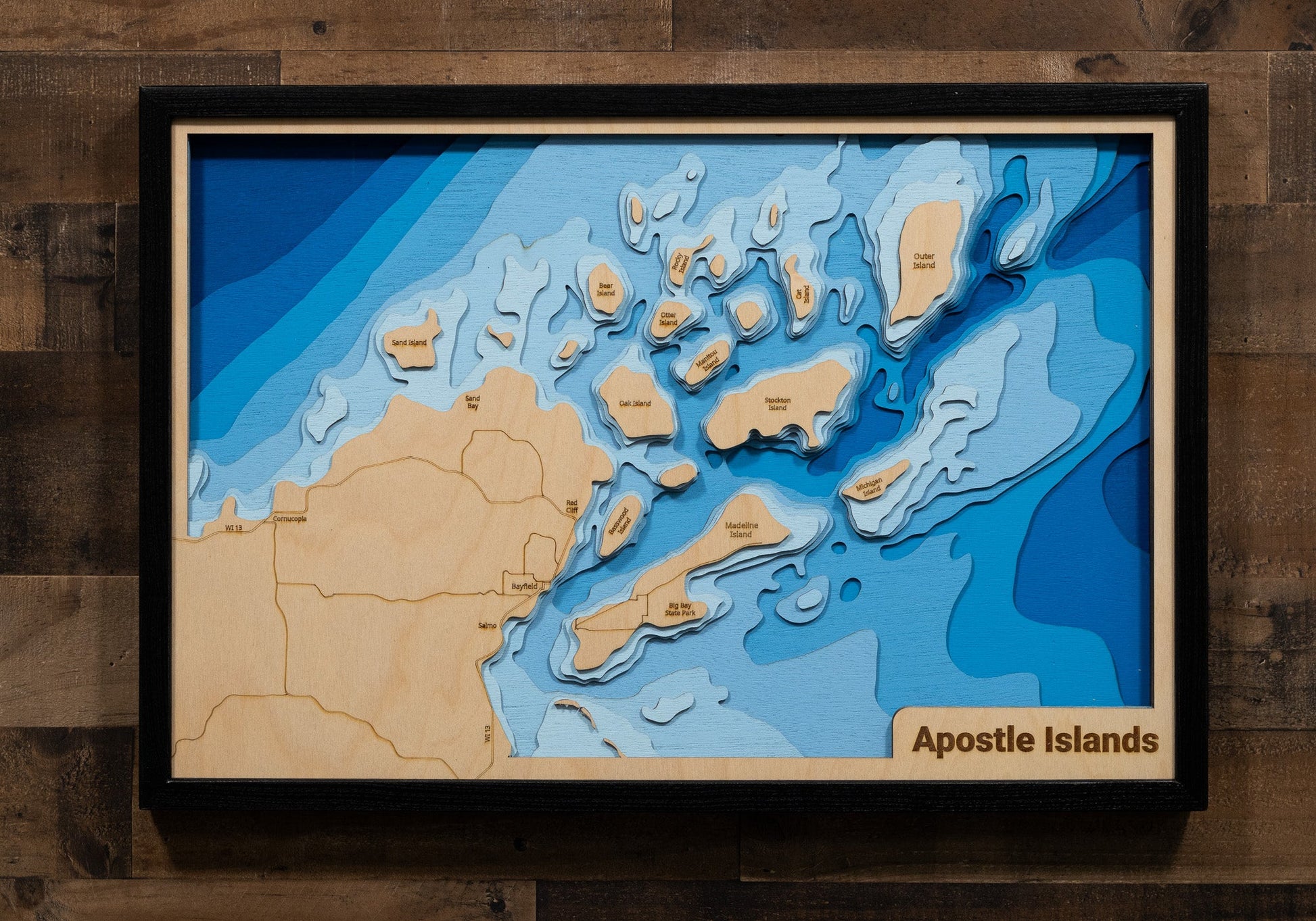 Topographic map of the Apostle Islands in a wooden frame on a wooden wall.