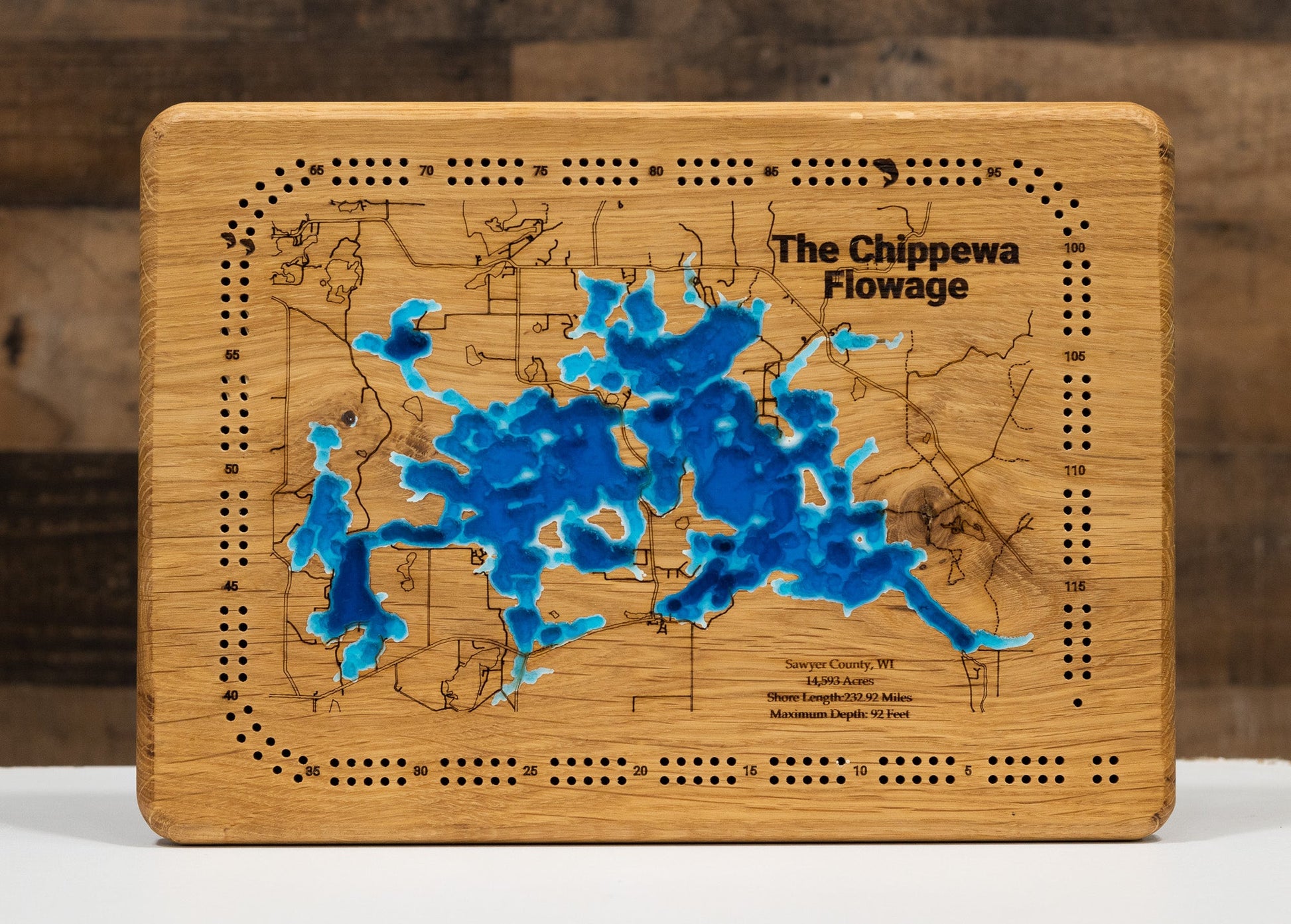 Wooden cribbage board with a map design and 'The Chippewa Flowage' text on a wooden background.