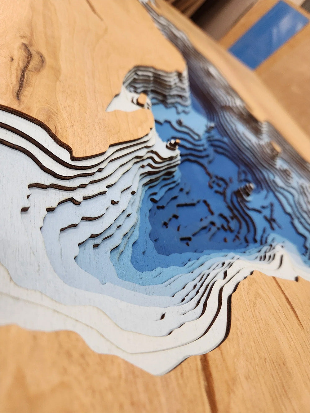 Topographic map model on a wooden surface