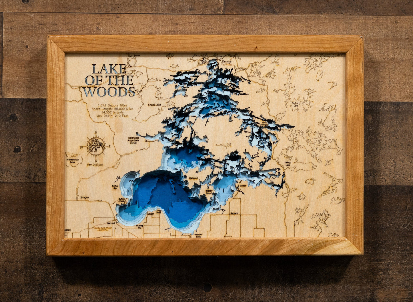 Wooden framed map of Lake of the Woods on a wooden surface