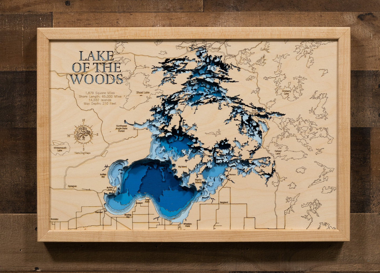 Wooden map of Lake of the Woods with blue water and wooden frame.