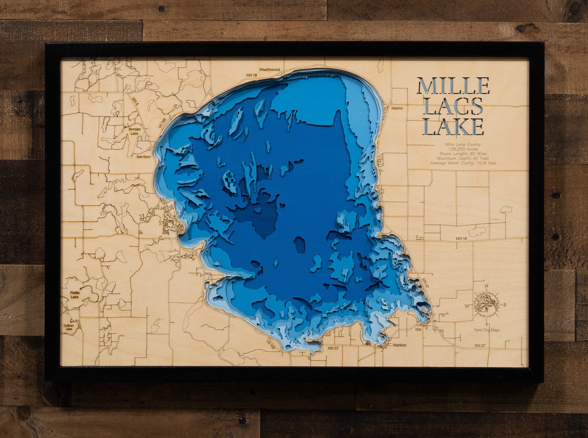 Topographic map of Mille Lacs Lake with a wooden texture and blue water, framed on a wooden background.